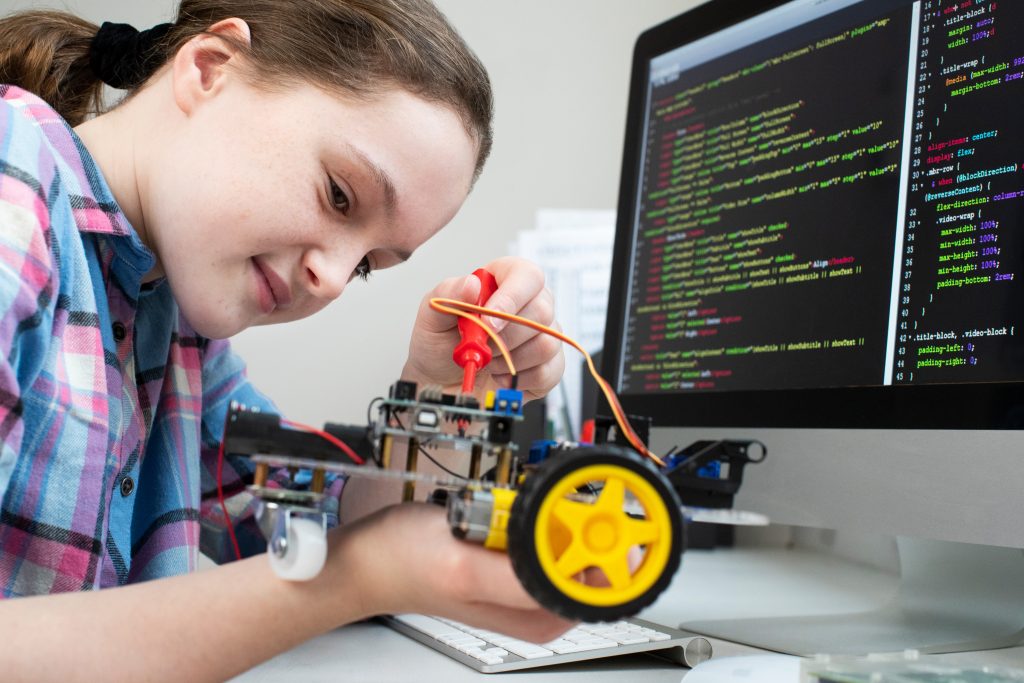 Female Pupil Building Robotic Car In Science Lesson coding